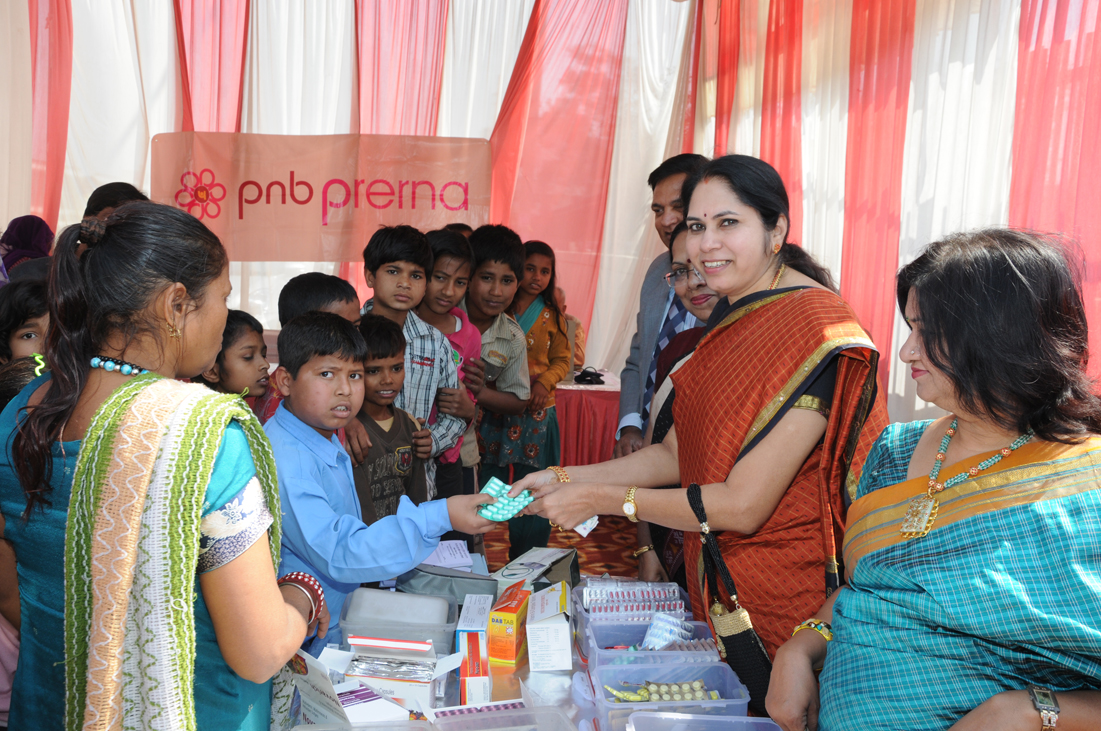 Pushpa Kamath, President, PNB Prerna, distributes medicines to underprivileged