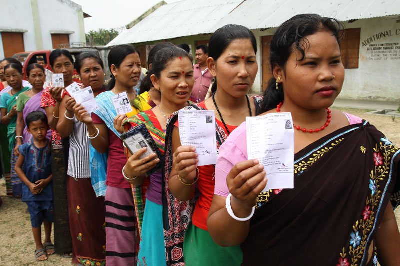 Tribal voters standing in a queue at a polling booth to cast their votes...