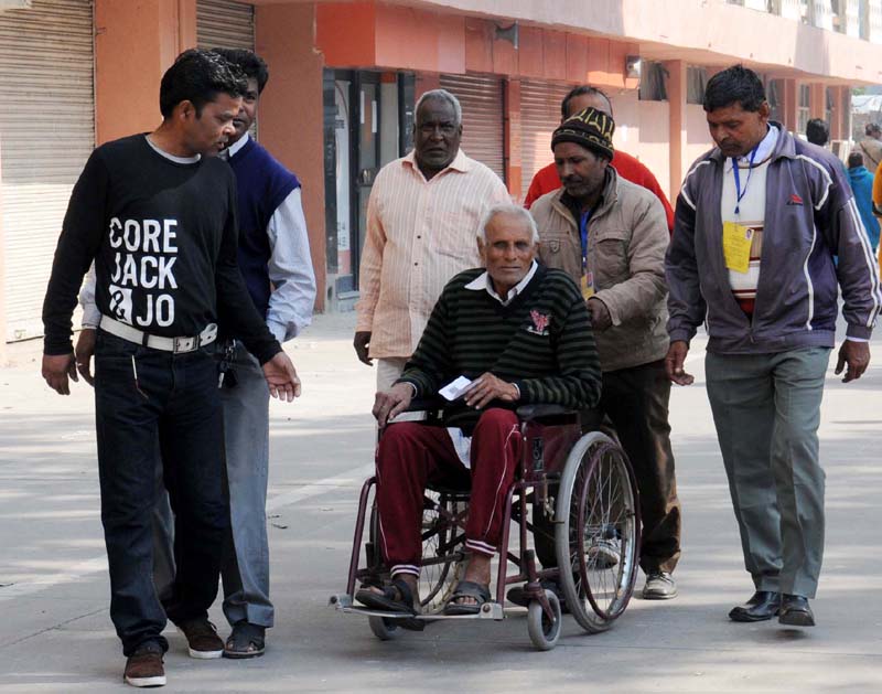 A physically handicapped voter being carried at a polling booth to ...