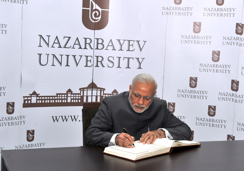 The Prime Minister, Shri Narendra Modi signing the visitors' book at the...